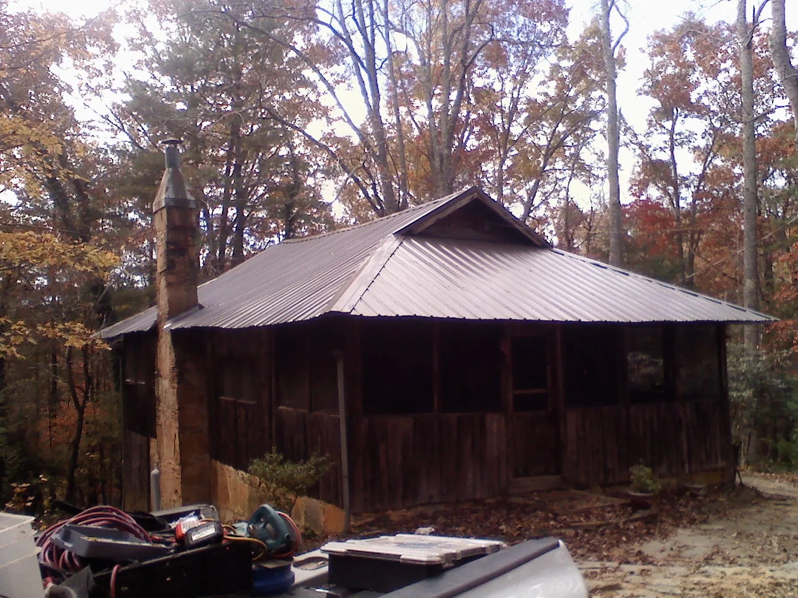 Brown metal hip roof on an old cabin with a stone chimney in Atlantic